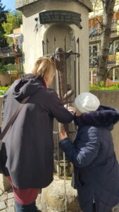 Egy tagunk éppen a vastuskót tapintja, mely egy fa alakú vasszobor, mely egy kápolna alakú talabzaton áll, ráccsal el van kerítve. Mellette segítője látszik