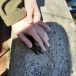 Egy kéz látszik, ahogy tapogatja a szomorú tank szobrot