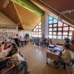 Kolléganőnk a Braille írógép használatát szemlélteti éppen a körülötte álló gyerekeknek