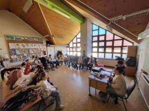 Kolléganőnk a Braille írógép használatát szemlélteti éppen a körülötte álló gyerekeknek