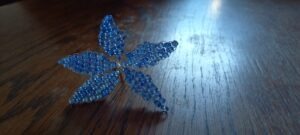 Egy elkészült virág, öt szirma van, lila színű gyöngyből