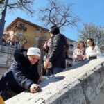 Egy résztvevő a fókuszban, aki kézzel tapintja a Rubik-kocka szobrot