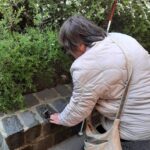 Egy résztvevő kezével tapintja a kutya szobrot