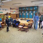 Körben ülnek a gyerekek és többen is éppen a fehérbotos közlekedést róbálják ki Dorka instruálásával