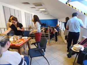 Életkép a közgyűlés után, a résztvevők és az asztalon finomságok látszanak