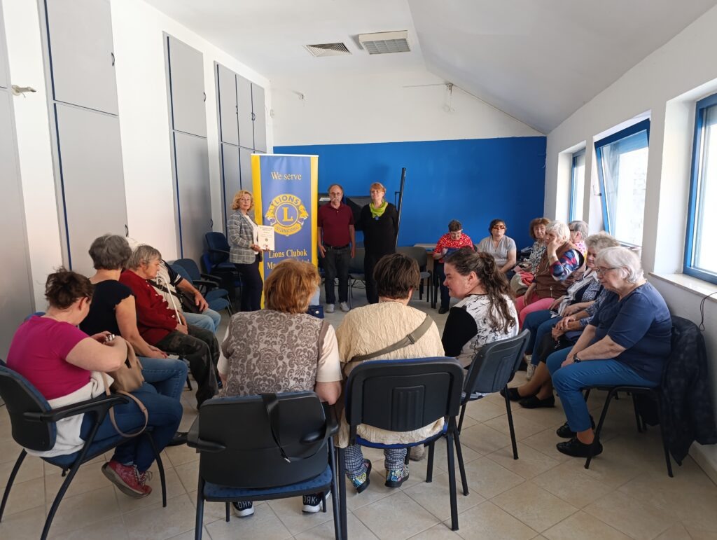 A rehabilitációs klubon a résztvevők körben ülnek, figyelik az elsősegélynyújtásról tartott előadást