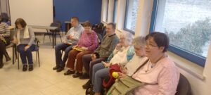 A résztvevők körben ülnek, énekelnek és az általuk választott hangszerrel zenélnek