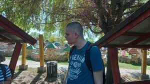 Egy résztvevő tag áll egy fa előtt, mögötte a középkori várak makettjei láthatók