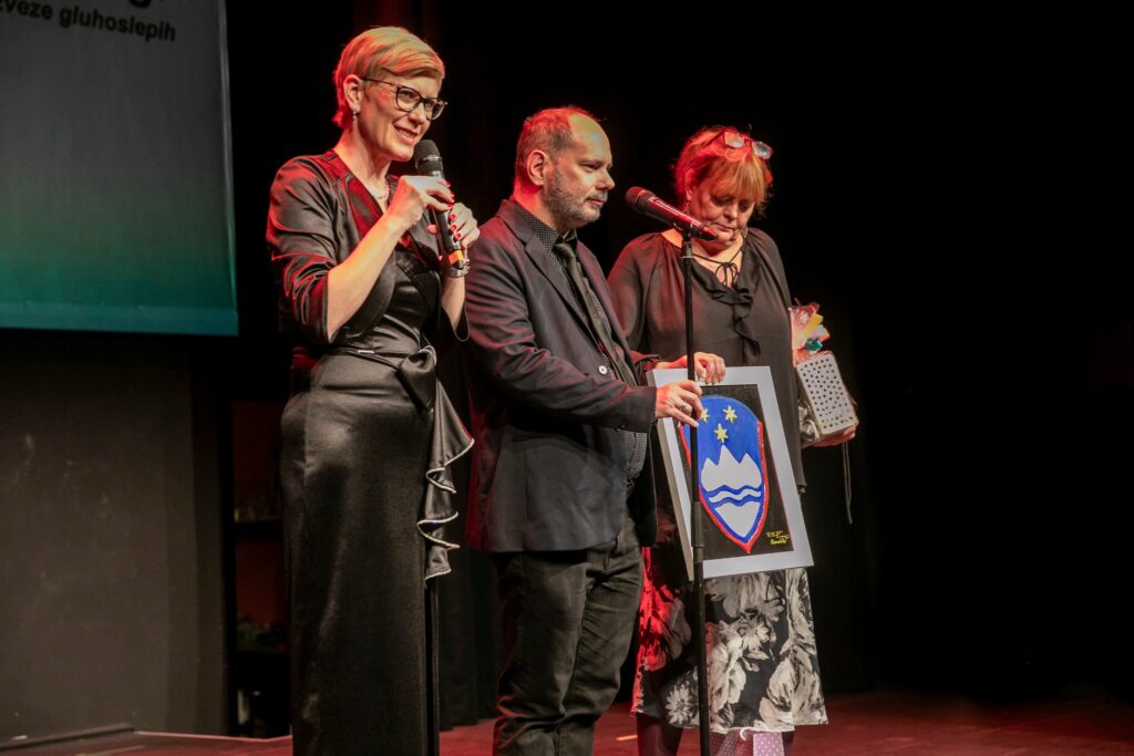 Ljubljana, Tomi ajándékot ad át a szlovén egyesület főtitkárának, Simona Gerenčernek, Dorka áll mellette