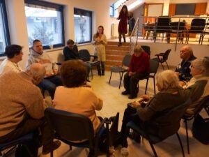 Az egyesületi nagy teremben körben ülnek a tagok, a klub vezető lefelé jön a lépcsőn