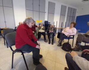 Az egyik résztvevő a kör közepén ül és egy dalt énekel