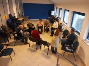 Fiatal hosszú barna hajú önkéntes gyógypedagógus hallgató, süteményt kínál körbe