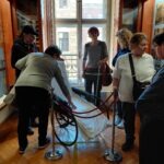 Mentésre használt kerekésszék, a résztvevők körbe állják, egyikük a karfát fogja éppen