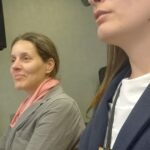 Kőrösiné Dr. Babinszki Vera, mellette személyi segítője ülnek és figyelnek a közlekedési konferencián